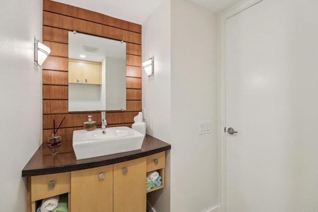 bathroom with vanity and wooden walls