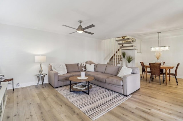 living room featuring crown molding, ceiling fan, and light hardwood / wood-style flooring