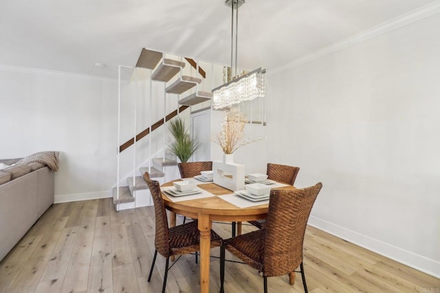 dining space featuring crown molding and light hardwood / wood-style floors