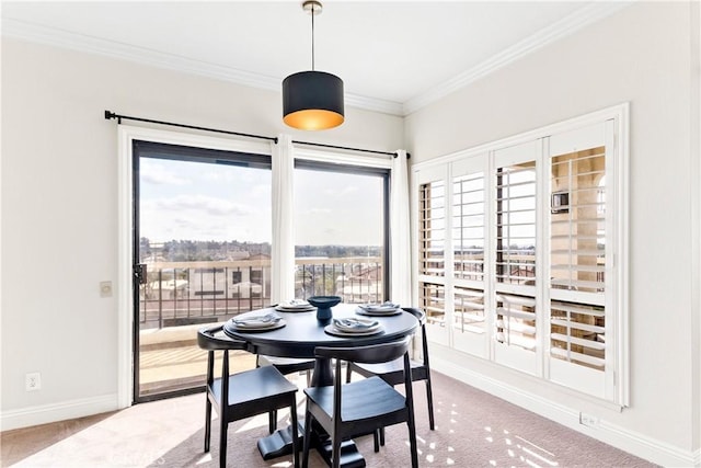 carpeted dining space with crown molding