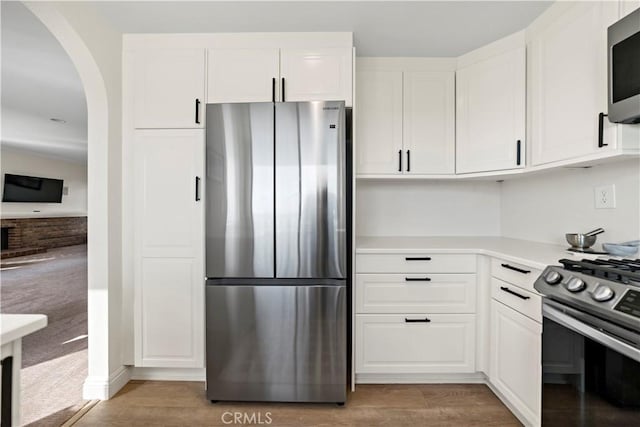 kitchen featuring white cabinetry, appliances with stainless steel finishes, and wood-type flooring