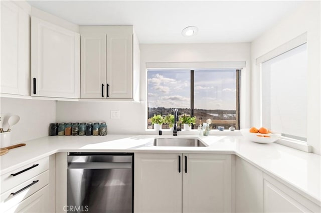 kitchen with dishwasher, sink, and white cabinets