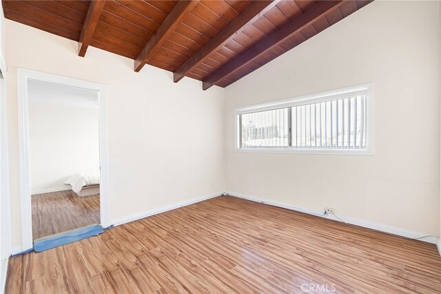 spare room with lofted ceiling with beams, wood ceiling, and light hardwood / wood-style flooring