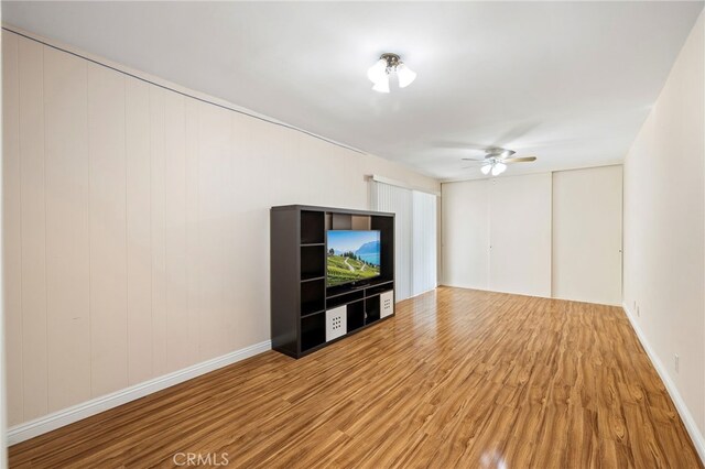 unfurnished living room with ceiling fan and light wood-type flooring