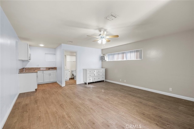 unfurnished living room featuring ceiling fan and light hardwood / wood-style floors