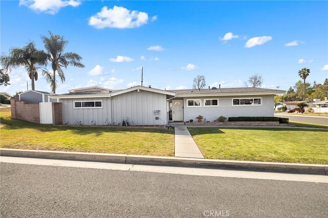 ranch-style house featuring a front lawn and fence