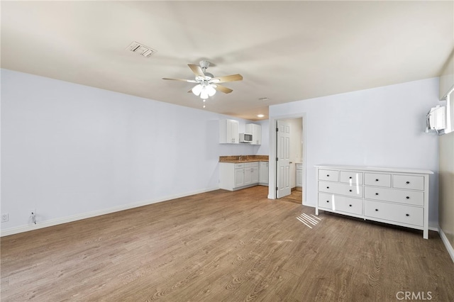 unfurnished living room featuring light hardwood / wood-style flooring and ceiling fan