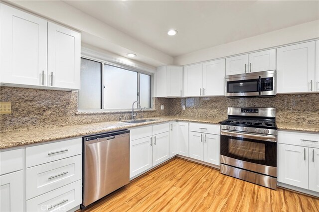 kitchen with white cabinetry, sink, tasteful backsplash, and appliances with stainless steel finishes