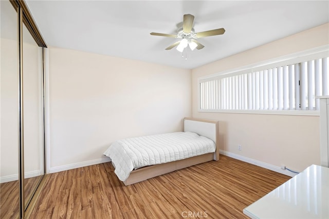 bedroom with hardwood / wood-style floors, a closet, and ceiling fan