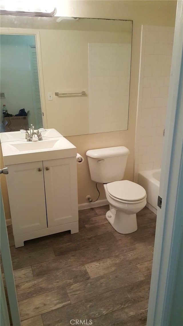 bathroom with hardwood / wood-style flooring, vanity, and toilet