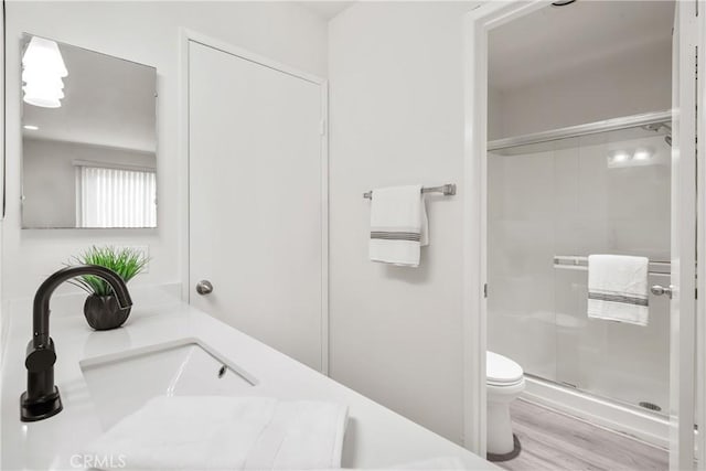 bathroom with walk in shower, vanity, toilet, and hardwood / wood-style floors