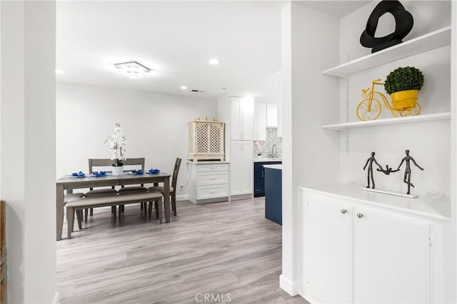 dining room featuring sink and light hardwood / wood-style floors