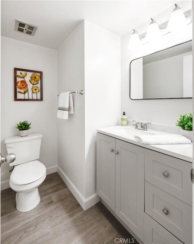 bathroom featuring vanity, toilet, and hardwood / wood-style floors