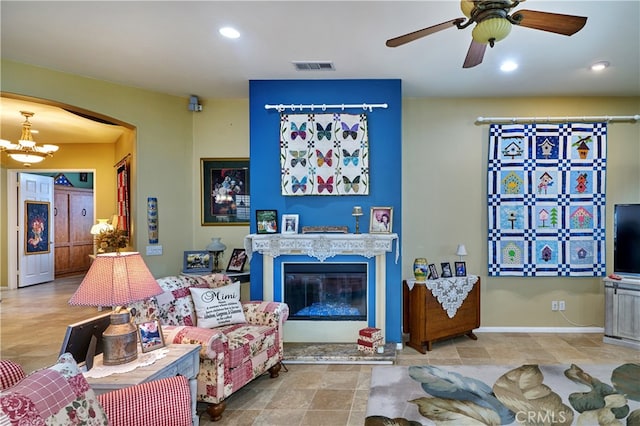 living room with ceiling fan with notable chandelier