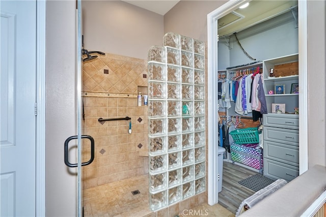 bathroom with wood-type flooring and a shower with shower door