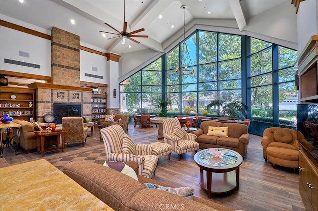 living room featuring a tile fireplace, a wealth of natural light, ceiling fan, and high vaulted ceiling