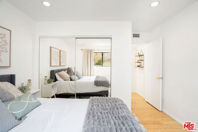 bedroom with a closet and light hardwood / wood-style flooring