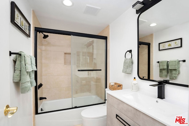 full bathroom with vanity, toilet, and combined bath / shower with glass door