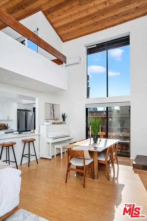 dining space featuring high vaulted ceiling, light hardwood / wood-style flooring, and wooden ceiling