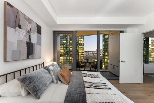 bedroom with dark hardwood / wood-style flooring, multiple windows, and access to outside