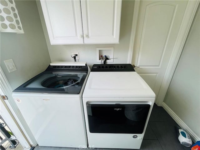 laundry room with baseboards, cabinet space, washing machine and clothes dryer, and tile patterned floors