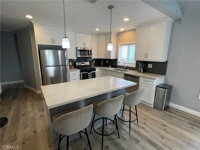 kitchen with stainless steel appliances, backsplash, a sink, and white cabinetry