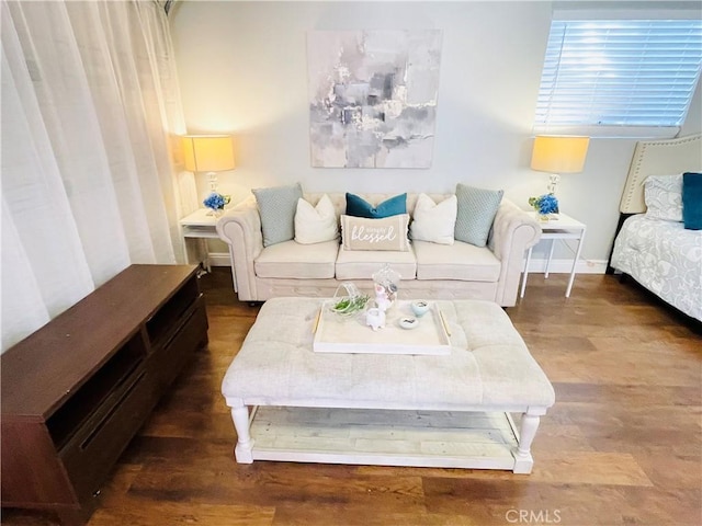 living area featuring baseboards and wood finished floors