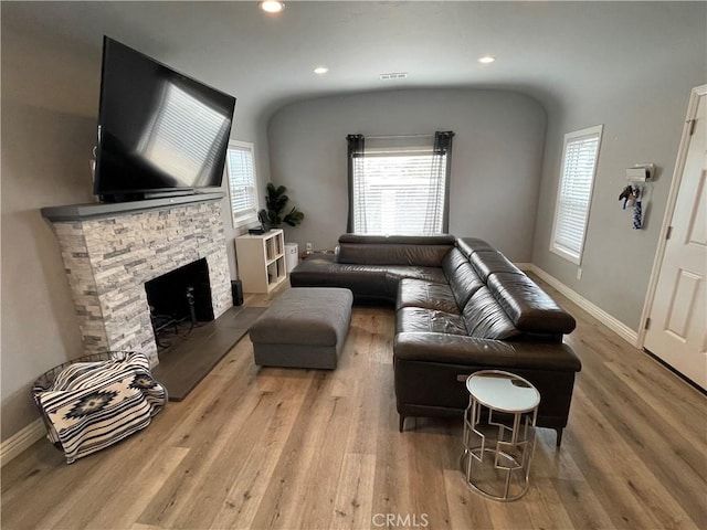 living area featuring a fireplace, baseboards, wood finished floors, and recessed lighting