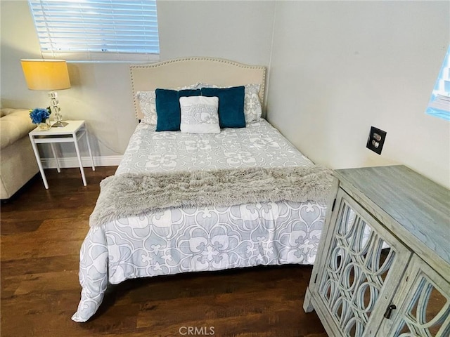 bedroom with baseboards and wood finished floors