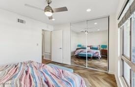 bedroom featuring parquet flooring, a closet, and ceiling fan