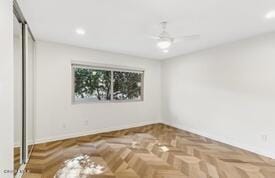 spare room featuring ceiling fan and parquet flooring