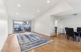 living room featuring wood-type flooring and vaulted ceiling