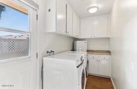 laundry area with cabinets, dark hardwood / wood-style floors, and washing machine and clothes dryer