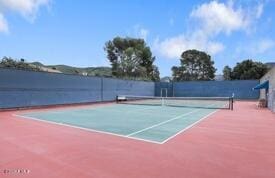 view of tennis court with basketball hoop