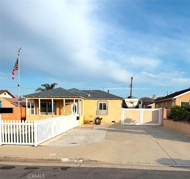 single story home featuring a fenced front yard, a gate, and stucco siding