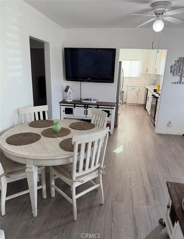 dining area featuring ceiling fan and light wood-style floors