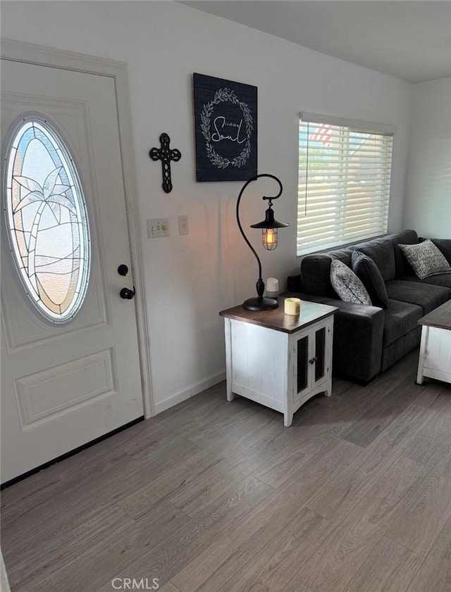 foyer featuring light wood-style flooring and baseboards