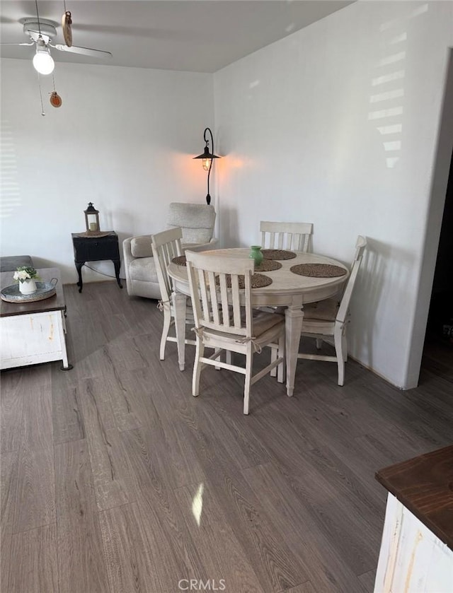 dining space with wood finished floors and a ceiling fan