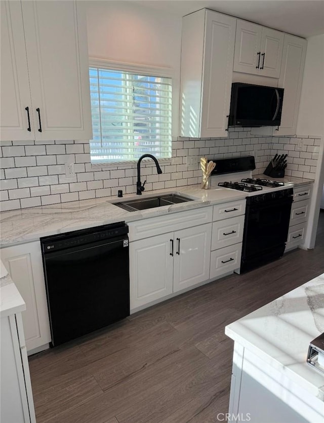 kitchen with black appliances, white cabinets, and a sink