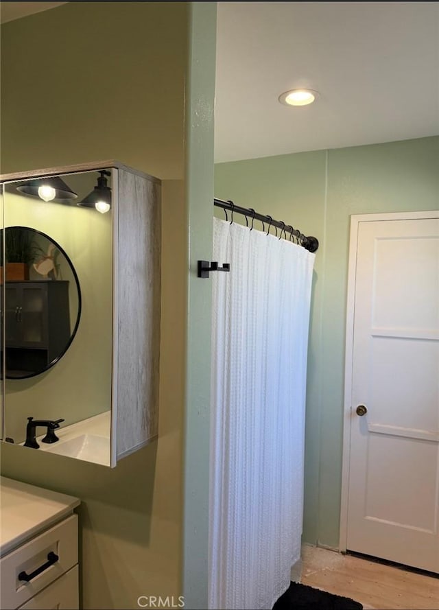 full bath with a shower with curtain, wood finished floors, vanity, and recessed lighting