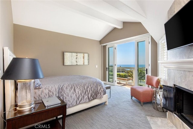 bedroom featuring a water view, lofted ceiling with beams, light carpet, a high end fireplace, and access to exterior