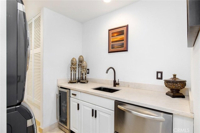 kitchen with wine cooler, stainless steel dishwasher, sink, and white cabinets