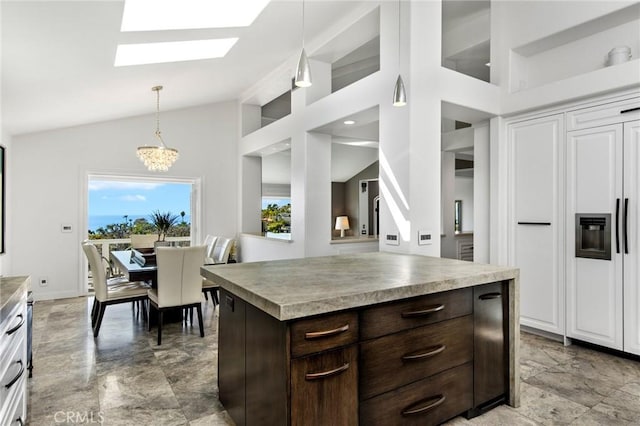 kitchen featuring lofted ceiling with skylight, dark brown cabinets, a kitchen island, a notable chandelier, and pendant lighting