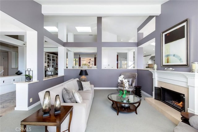 carpeted living room with lofted ceiling with beams and a premium fireplace