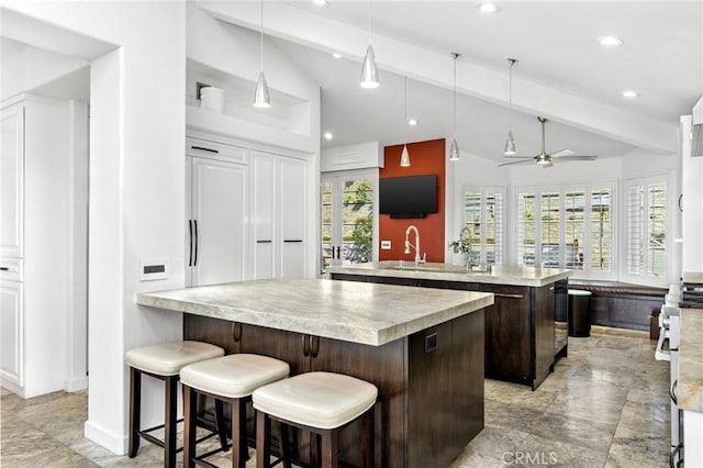 kitchen featuring vaulted ceiling with beams, hanging light fixtures, a wealth of natural light, and kitchen peninsula