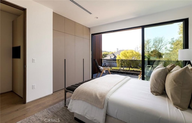 bedroom with light hardwood / wood-style flooring and a closet