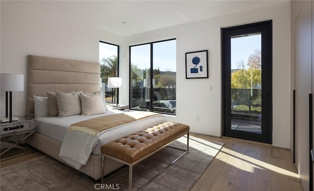 bedroom featuring hardwood / wood-style floors and access to outside