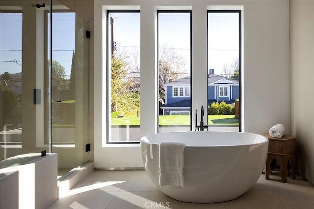 doorway to outside featuring light tile patterned floors and a wealth of natural light