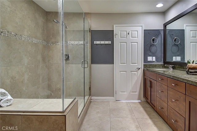 bathroom featuring tile patterned floors, vanity, and a shower with door