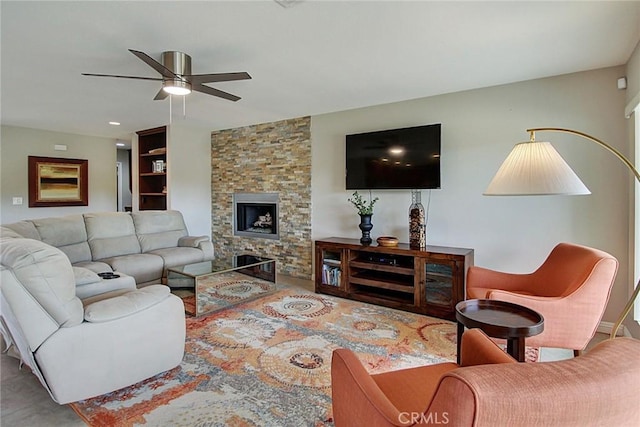 living room with ceiling fan and a fireplace